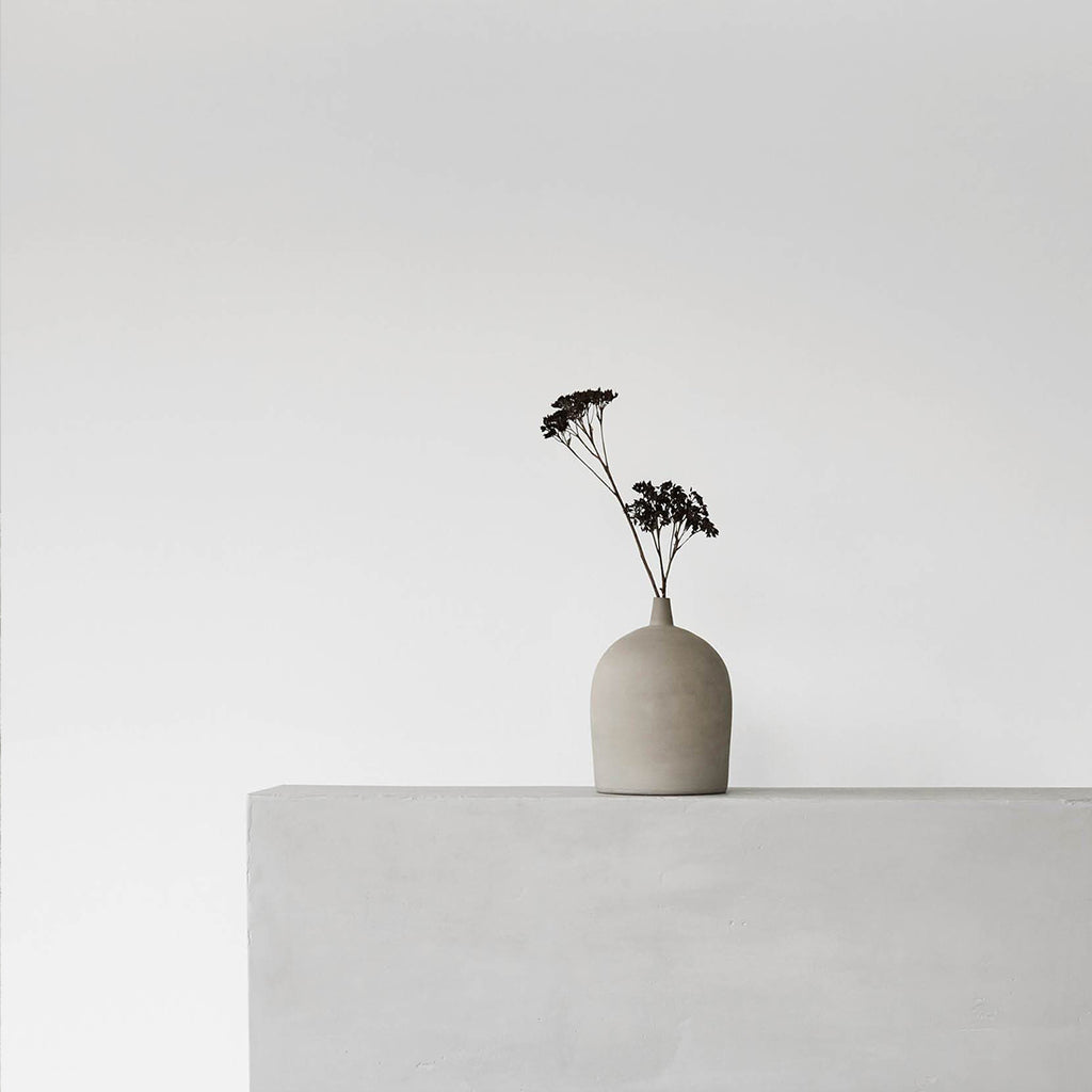 Lille terrakotta vase enkel og elegant styling med én blomst